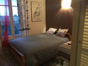 um pequeno quarto com uma cama e uma janela em Le Chant Des Oiseaux em Magny-les-Hameaux