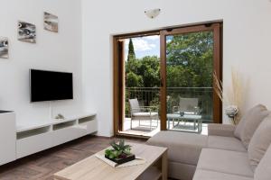 a living room with a couch and a television at Apartments Villa Diamant with Pool & Whirlpool in Čižići