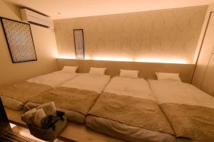 a large bed in a bedroom with a light at Guest Villa Hakone Yumoto 101 in Hakone
