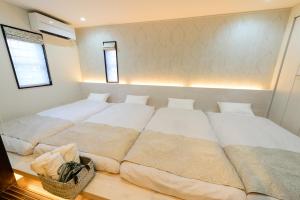 a large white bed in a room with two windows at Guest Villa Hakone Yumoto 101 in Hakone