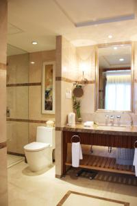 a bathroom with a toilet and a sink and a mirror at Glarun Jinling Hotel in Nanjing