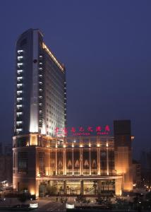 un grande edificio con scritte cinesi sopra la notte di Jinling Jingyuan Plaza a Nanjing