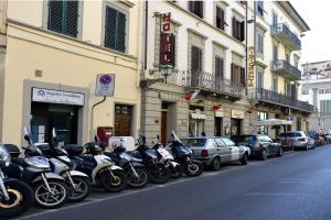una fila de motocicletas estacionadas al lado de una calle en Ognissanti 67, en Florencia