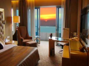a hotel room with a bed and a desk and a window at Glarun Jinling Hotel in Nanjing