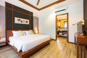 a bedroom with a bed and a desk and a television at Villa Raeya in Ao Nang Beach +21 photos