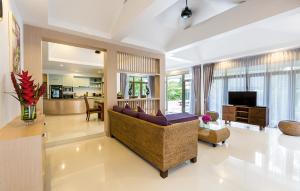 een woonkamer met een bank en een televisie bij Villa Raeya in Ao Nang Beach