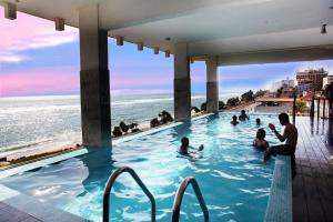 un grupo de personas en una piscina con vistas al océano en Mirage Colombo en Colombo