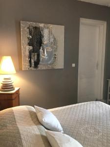 アルカションにあるLa Maison de Lillyのベッドルーム1室(ベッド1台付)が備わります。壁には絵画が飾られています。