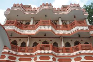 - une vue extérieure sur un bâtiment avec des balcons rouges dans l'établissement Sajjan Niwas, à Jaipur