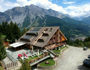 a building with solar panels on the roof with mountains at Residence Mirage in Oga