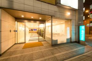 東京的住宿－東京大手町芬迪別墅酒店，带有玻璃门的建筑走廊
