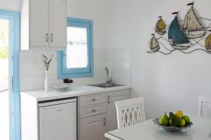 eine Küche mit einem Waschbecken und einer Schale mit Obst auf dem Tisch in der Unterkunft Folegandros Apartments in Folegandros Chora