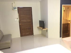 een woonkamer met een deur en een televisie bij A-Place Suvarnabhumi in Lat Krabang