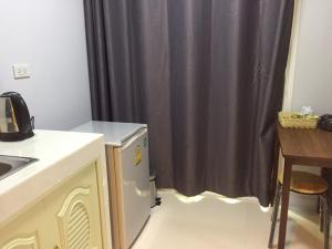 a kitchen with a sink and a shower curtain at A-Place Suvarnabhumi in Lat Krabang