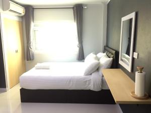 a bedroom with a large white bed with a window at A-Place Suvarnabhumi in Lat Krabang