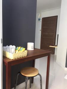 a table with a stool and a table with toiletries at A-Place Suvarnabhumi in Lat Krabang