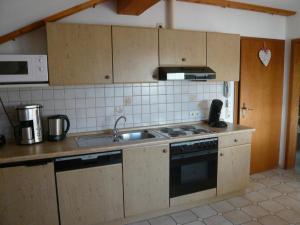een keuken met een spoelbak en een fornuis bovenste oven bij Gastehaus Helga in Bodenmais