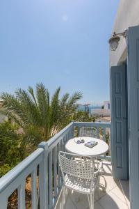 um pátio com uma mesa e cadeiras numa varanda em Castle Mansions em Naxos Chora