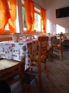 a dining room with a table and chairs and windows at Garnì Sella Cipriani in Borgo