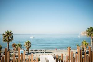 a beach with chairs and umbrellas and the ocean at H Boutique Peña Parda in La Herradura