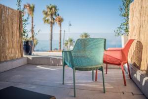 two chairs and a table with palm trees and the ocean at H Boutique Peña Parda in La Herradura