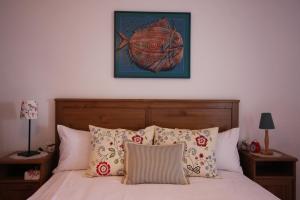 ein Bett mit Kissen und ein Bild von einem Fisch an der Wand in der Unterkunft Apartments Panoramic in Lovran