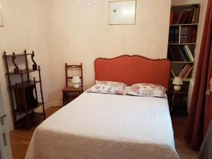 a bedroom with a bed with a red headboard at Gîte l'Hermine in Antrain