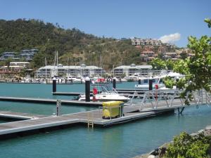 a dock with boats and people on it at Boathouse Port of Airlie in Airlie Beach