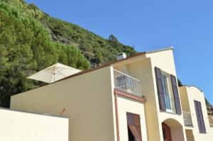 a white building with a mountain in the background at House Grecale in Moneglia +14 photos
