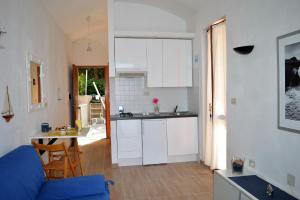 a kitchen with a table and a blue couch in a room at House Grecale in Moneglia
