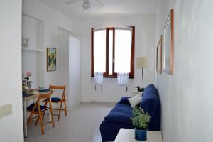 Una sala de estar con un sofá azul y una mesa. en House Libeccio by Holiday World, en Moneglia