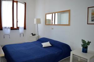 Un dormitorio con una cama azul y un espejo. en House Libeccio by Holiday World, en Moneglia