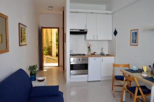 Una cocina y una sala de estar con un sofá y una mesa. en House Libeccio by Holiday World, en Moneglia