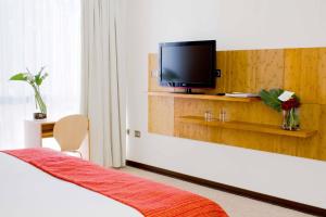 a hotel room with a bed with a tv on the wall at Open Hotel in Quillota