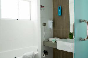 a bathroom with a white sink and a shower at Open Hotel in Quillota +20 photos