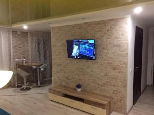 a living room with a tv on a brick wall at Apartment on Pyrohova 25 in Vinnytsya