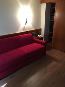 a red couch in a room with a red wall at Dürer-Hotel in Nuremberg