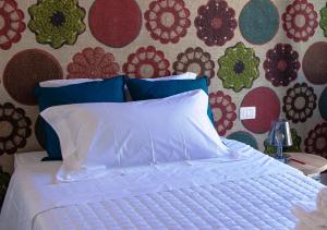 Una cama con sábanas blancas y almohadas azules en un dormitorio. en Catania Charming House, en Catania