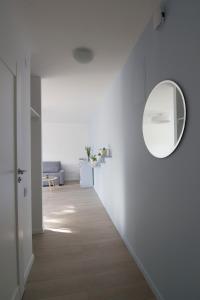 een hal met een spiegel en een witte muur bij Blue city apartment in Klaipėda