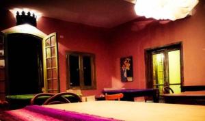 Habitación con mesa, sillas y pared roja. en Quinta y Eventos La Quebrada en Río Ceballos