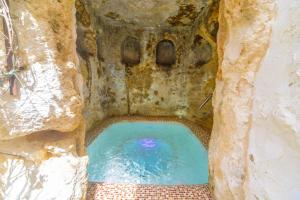 Casa Spa La Agueda y Robledo في Peñaflor: تجمع صغير للمياه في كهف بجدار حجري