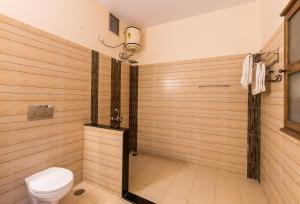 a bathroom with a toilet and a shower with wooden walls at Jaswant Niwas in Jodhpur