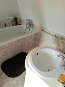 a bathroom with a white tub and a sink at Apartman Adele in Rumburk