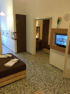 a hotel room with a bed and a flat screen tv at Villa Jeanna in Troulos