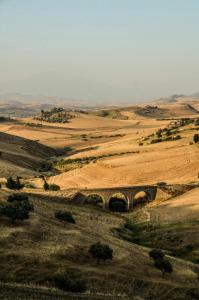 uma ponte velha no meio de um campo em Casa Pinù em San Michele di Ganzaria