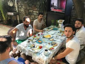 a group of men sitting around a table eating food at Tay Pansiyon in Bodrum City