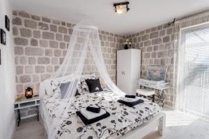 a bedroom with a white bed with a canopy at Luštica Apartments in Luštica