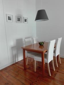 a dining room table with white chairs and a lamp at SoQuiet in Lisbon