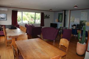 a dining room with tables and purple chairs at Riverstone Lodge in Turangi