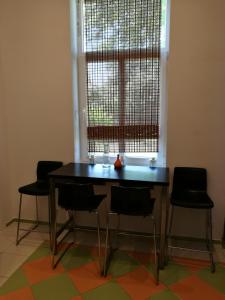 a table and chairs in a room with a window at Bartas apartment in Liepāja